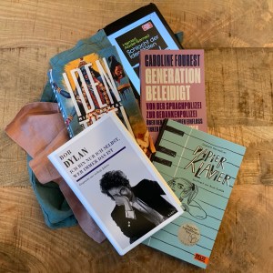 Dekorativ durcheinander auf den Tisch gelegt: Caroline Fourest, Generation beleidigt; Bob Dylan, Ich bin immer nur ich selbst (Interviewsammlung); Mithu Sanyal, Identitti; Elisabeth Steinkellner und Anna Gusella, Papierklavier; Hamed Abdel-Samad, Schlacht der Identitäten (eBook auf dem iPad mini)