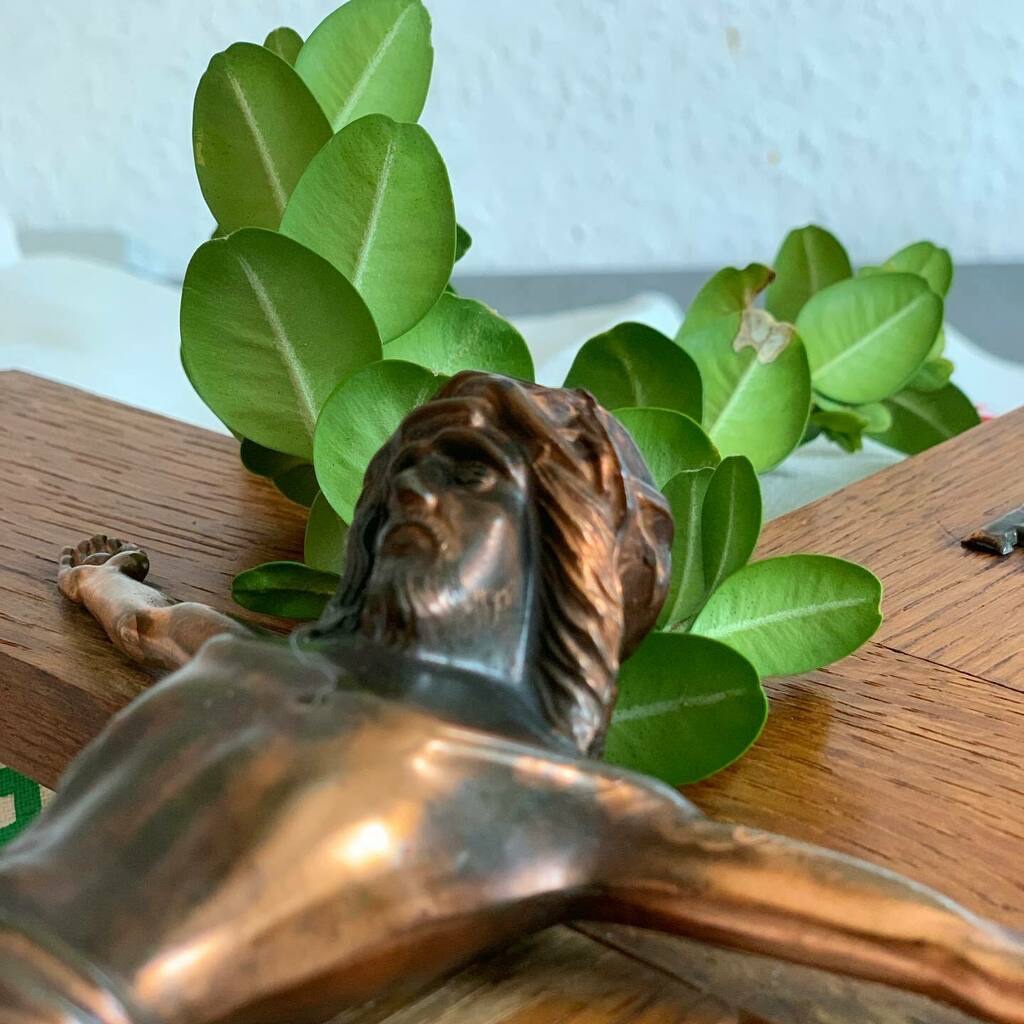 Der obere Teil des Kruzifixes liegend, mit dem frischen Buchsbaumzweig hinter Jesu rechter Schulter.