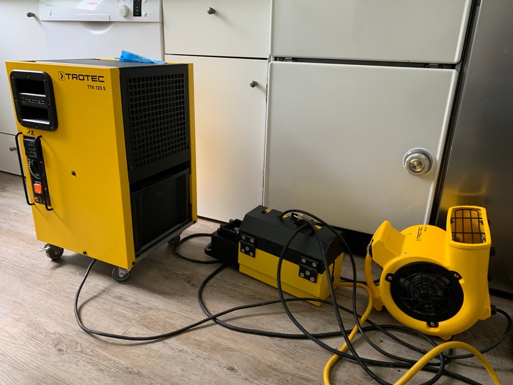 Trocknungsgerät mit zugehöriger Steckdosenleiste und Ventilator in der Küche.