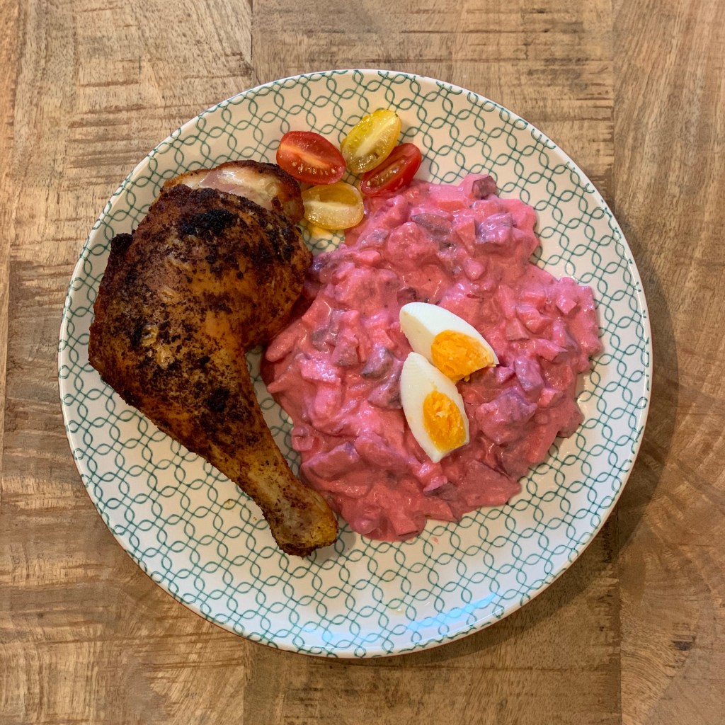 Hähnchen und Salat wie beschrieben und mit zwei Vierteln hartgekochtes Ei und zwei halbierten Mini-Tomaten dekoriert.