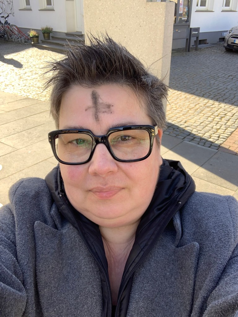 Selfie auf dem Kirchplatz mit Aschenkreuz.