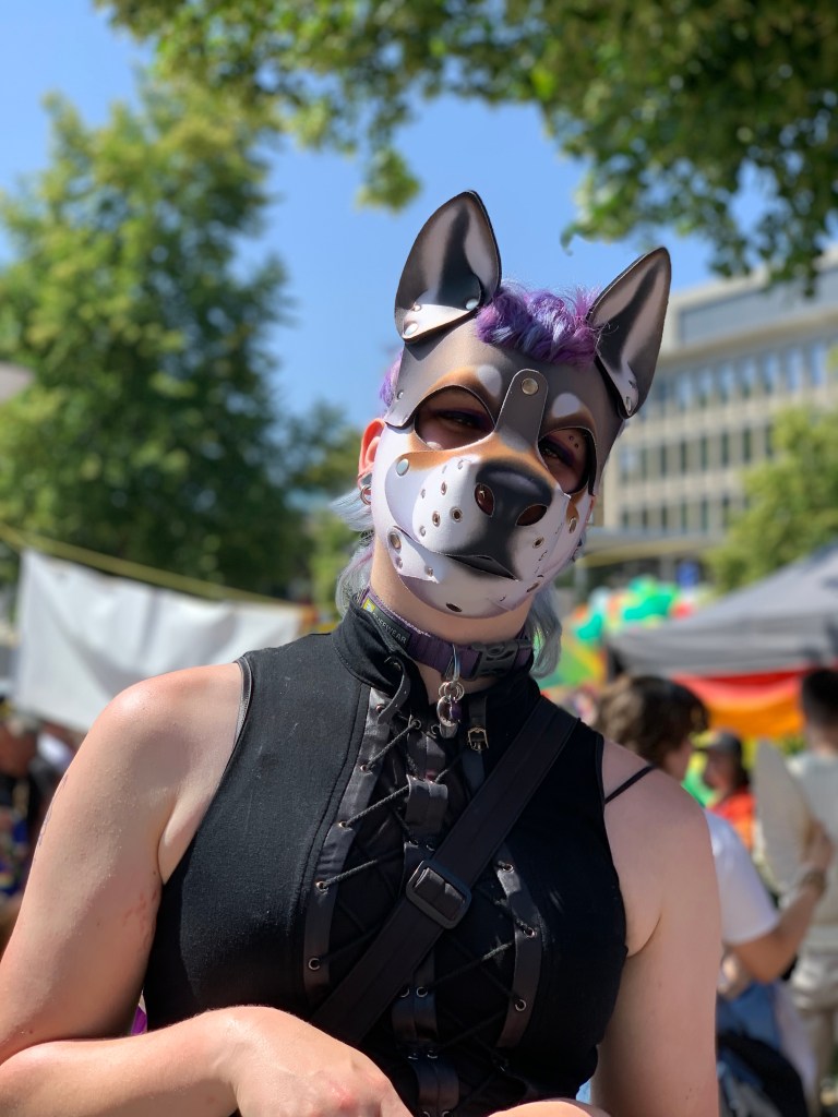 Ein Puppy mit Halsband und schwarzem Oberteil. (Ein Puppy ist ein Mensch mit Hundemaske.)