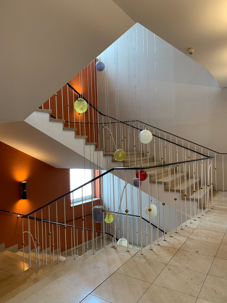 Treppenhaus mit bunten Glasbällen als Lichter.