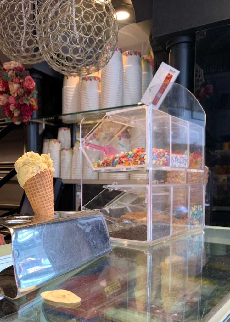 Blick auf die Eistheke, wo mein Hörnchen in einem dieser silbernen Halter steckt.